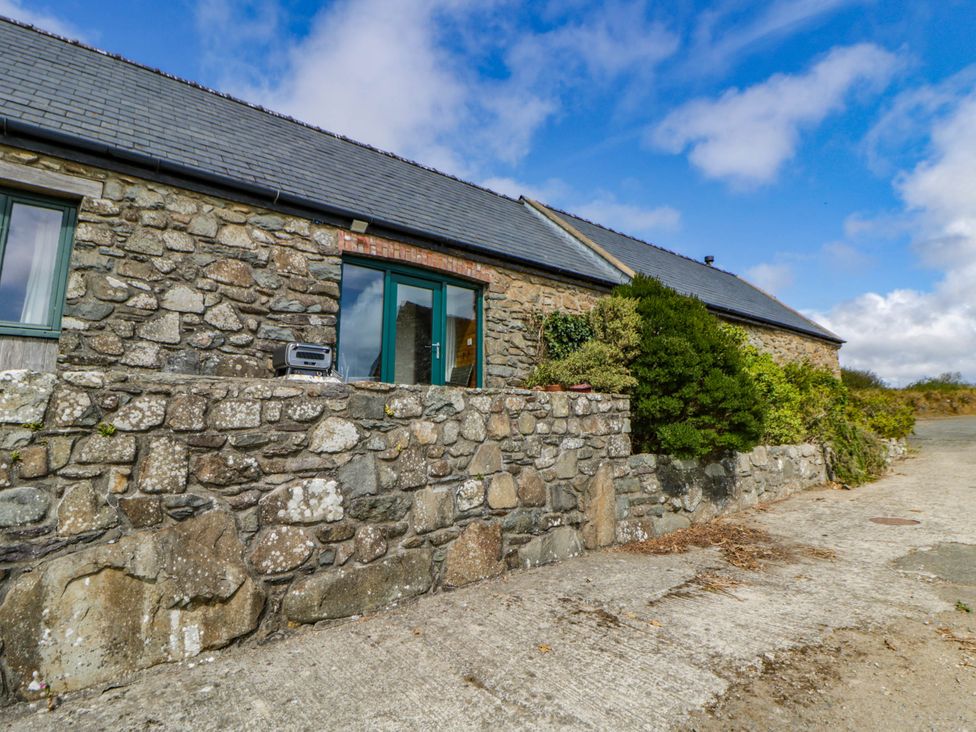 Outdoor area beside the cottage's stone wall and window