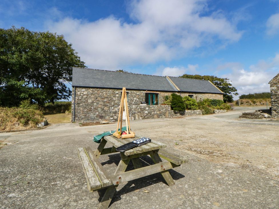 Outdoor seating area with picnic table beside stone buildings