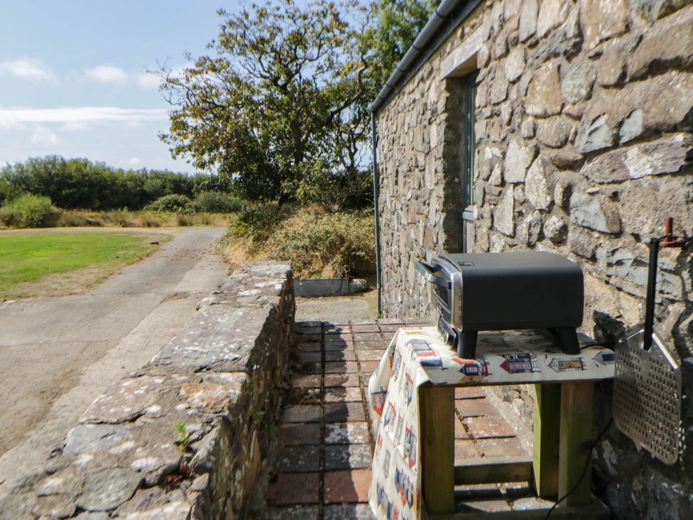 Barbecue grill on a table beside a stone wall